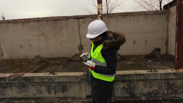 Woman inspector take a pictures on smartphone at construction of a building