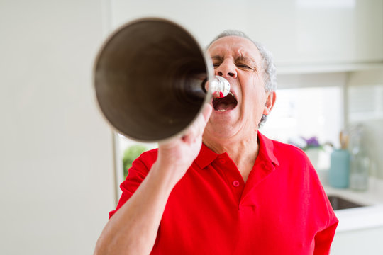 Senior man shouthing excited through vintage metal megaphone