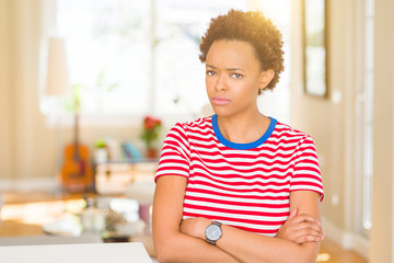 Young beautiful african american woman at home skeptic and nervous, disapproving expression on face with crossed arms. Negative person.