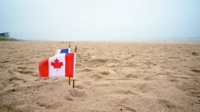 Canadian and French flag fly on Juno Beach