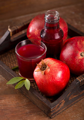 pomegranate juice and pomegranate fruit on wooden background