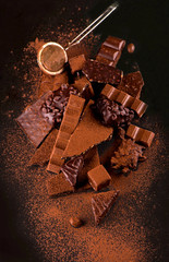 chocolate pieces and cocoa powder on wooden background