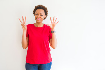 Young beautiful african american woman over white background showing and pointing up with fingers number eight while smiling confident and happy.