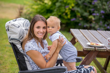 Young mother, holding her baby boy, breastfeeding him in the afternoon