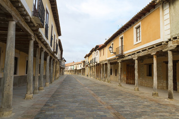 Fototapeta na wymiar Vista de la calle principal del Pueblo de Ampudia en Palencia. España, con sus característicos soportales