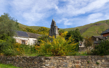 Espada&ntilde;a, campanario de Iglesia de piedra en paisaje oto&ntilde;al de pueblo en una hondonada entre monta&ntilde;as. Burbia, Le&oacute;n. Espa&ntilde;a