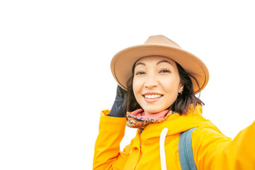 Asian Woman taking selfie in yellow coat and hat isolated on white. Travel in autumn season concept