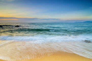 Fototapeta na wymiar Travel And vacation concept background, beautiful tropical beach sunrise sea view. soft wave hitting sandy beach
