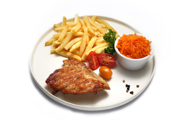 Grillowany filet z kurczaka z frytkami. Potrawa na talerzu na białym tle. © foodandcook