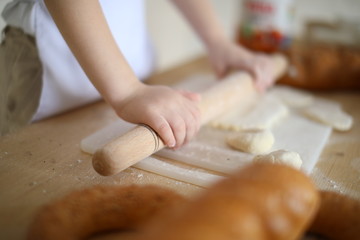 in the kitchen the baby rolls and plays with the dough and make pizza and bread