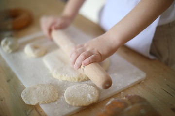 Fototapeta na wymiar in the kitchen the baby rolls and plays with the dough and make pizza and bread