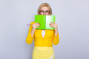 Portrait of blonde woman with books and pen