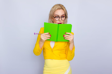 Portrait of blonde woman with books and pen