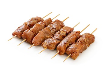 Raw chicken skewers on a white background