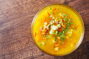 chicken soup with vegetables and rice in glass Bowl on wooden table background