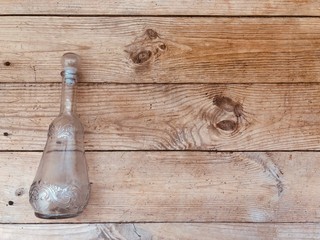 Glass bottle on the background of gray wooden boards
