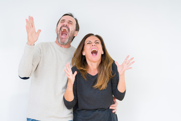 Beautiful middle age couple in love over isolated background celebrating mad and crazy for success...