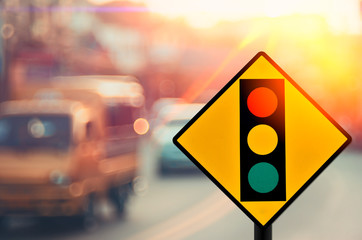 Traffic light warning sign on blur traffic road with colorful bokeh light abstract background.
