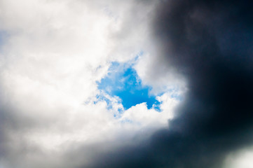 a piece of blue sky in dark clouds