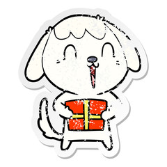 distressed sticker of a cute cartoon dog with christmas present