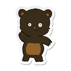 sticker of a cartoon waving black bear