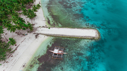 Pier with a boat in the middle of the blue water top view