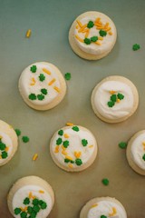 St Patricks day frosted cookies with green clover leaf sprinkles, selective focus