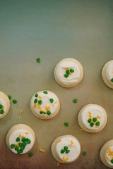 St Patricks day frosted cookies with green clover leaf sprinkles, selective focus