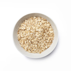 White bowl with oat-flakes cut out. Top view.
