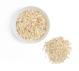 A bowl with oat-flakes and pile of oats cut out. Top view.