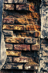 background of old dirty cracked brickwork of bricks of red, yellow and black hue
