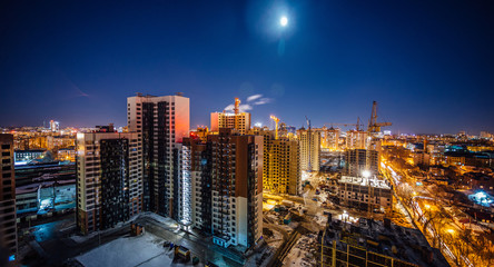 Construction of modern high multistory residential buildings, night aerial view of building yard