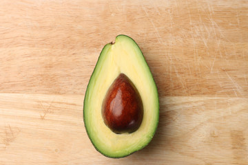 half avocado on wooden background top view
