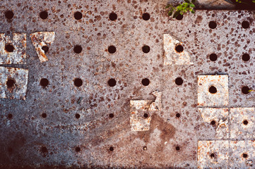 background of old darkened scuffed and scratched gray concrete floor with remnants of floor tiles and rust