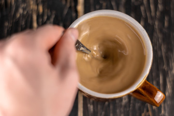 Top view of white cup of coffee isolated on brown background