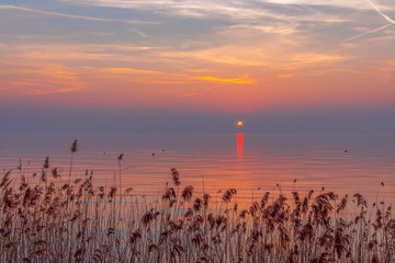 Amazing colorful sunset during fog on Lake Garda, Italy. Moody landscape.