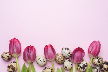 Fototapeta na wymiar Bright flowers tulips and quail eggs on colors background. Spring and Easter holiday concept with copy space