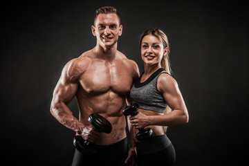 Sporty young couple posing on black background - 251596440