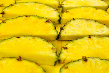 Pineapple juicy yellow slices background. Top view.