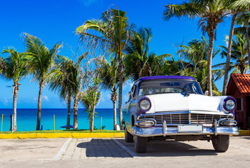 Blau weisser amerikanischer Oldtimer parkt am Strand in Varadero in Cuba - Serie Kuba Reportage - obrazy, fototapety, plakaty