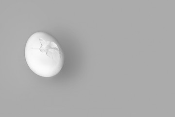 white egg with a crack on a gray background.