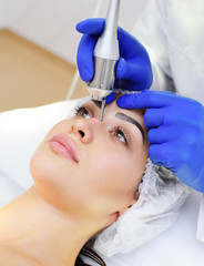Laser cosmetology. The doctor removes pigmentation-moles or warts patient neodymium laser.