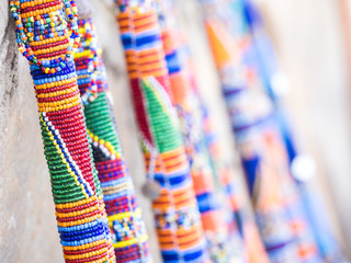 Maasai rungu (club) decorated with beads and sold as a souvenir at a local Maasai Market. Close up. - obrazy, fototapety, plakaty