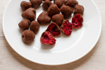 raspberry in chocolate on a white plate