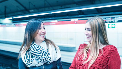 Couple of female friends talking in the subway station