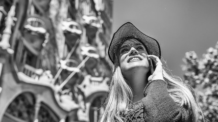 Happy young woman with straw hat looking to city buildings