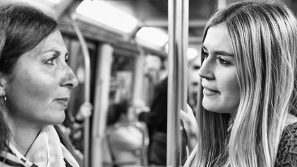 Couple of female friends talking in the subway train