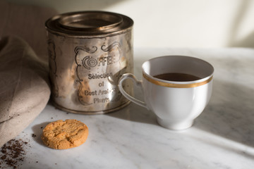 Cozy kitchen scene, cup of coffee on a marble table with cookie