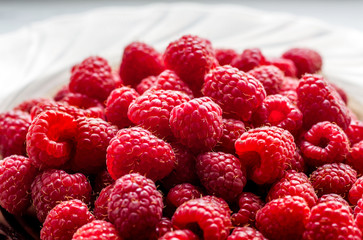 Red ripe raspberries in the plate are ready for consumption_