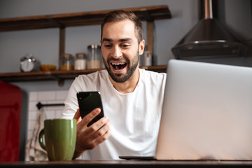 Happy young man using laptop computer